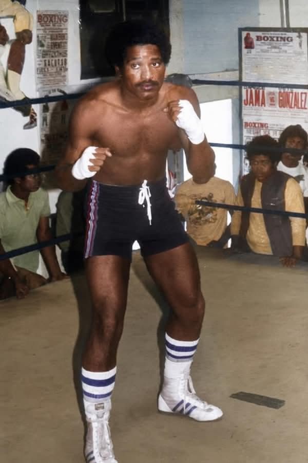 Boxer shadow-boxing in a 1970s gym ring