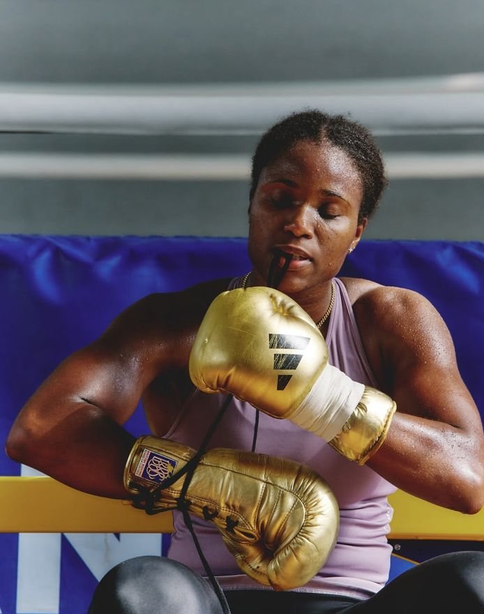 Boxer lacing golden gloves before training